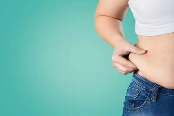 Image of woman pinching her love handles to show weight gain Scottish